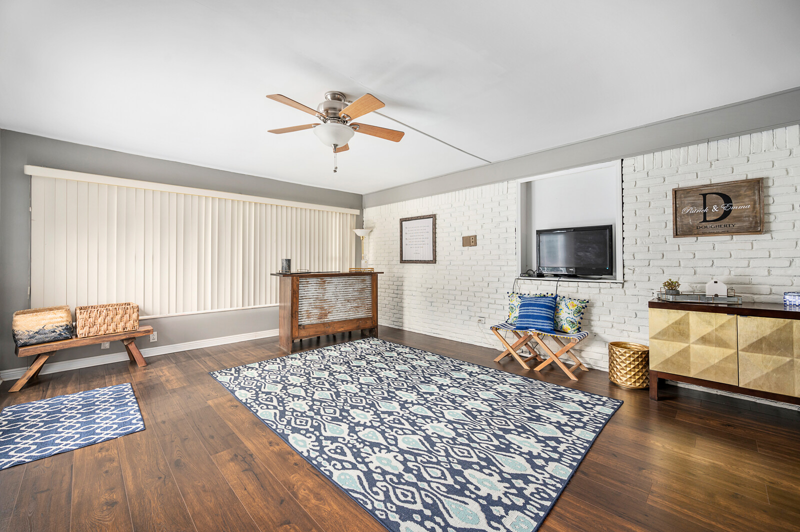 Residential living area with white brick wall and wood flooring